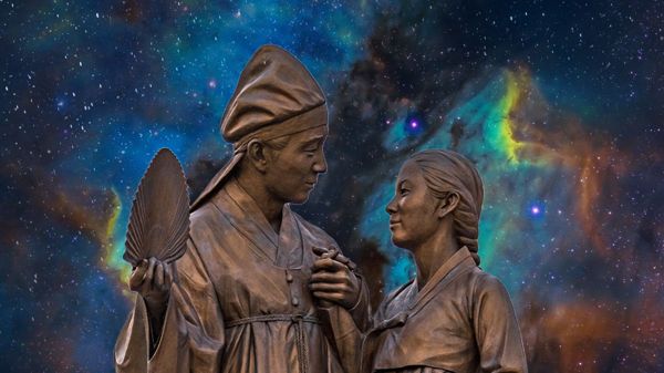 Statue of an older Korean couple holding hands with a decorative starry background