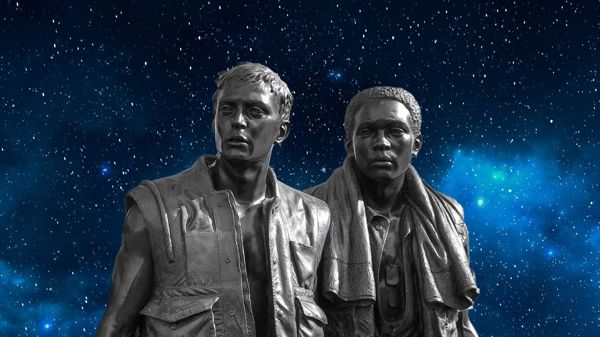 Statue of two young men from a Vietnam war memorial with background of starry sky